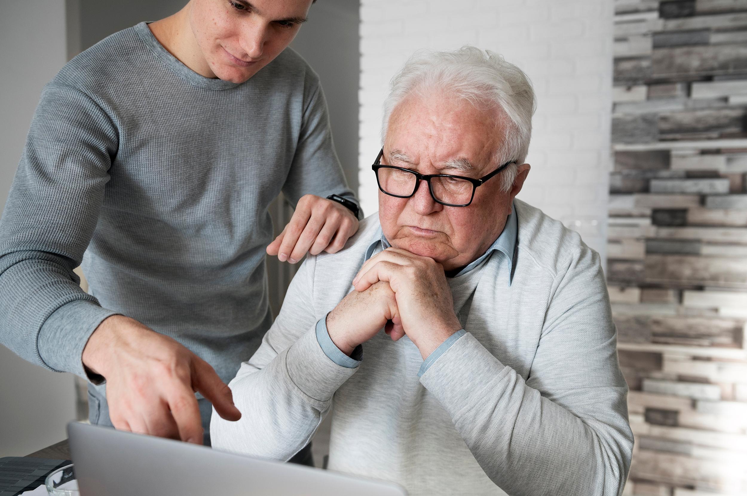 persoon helpt bejaarde met computer
