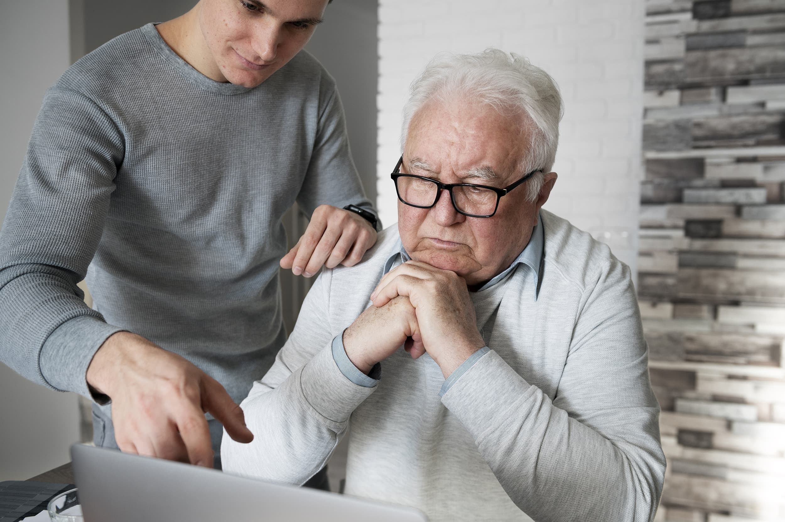 persoon helpt bejaarde met computer